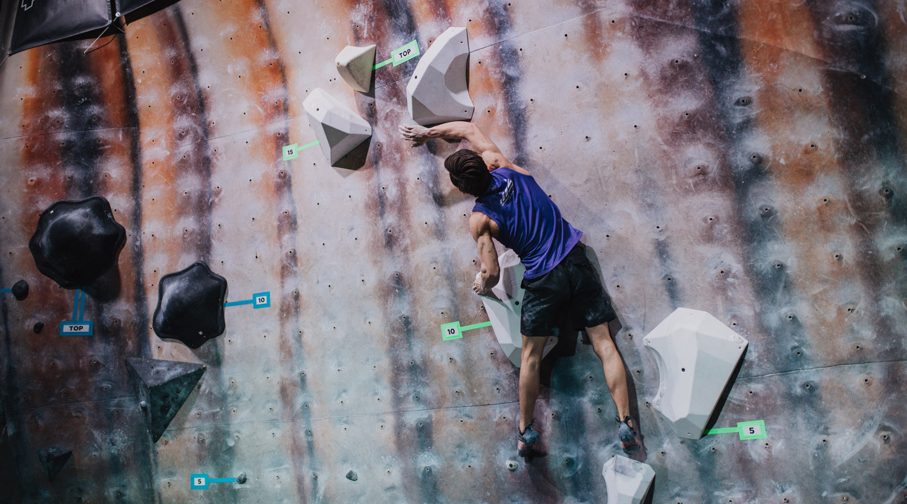 A climber climbs on the so ill level family holds during a climbing competition