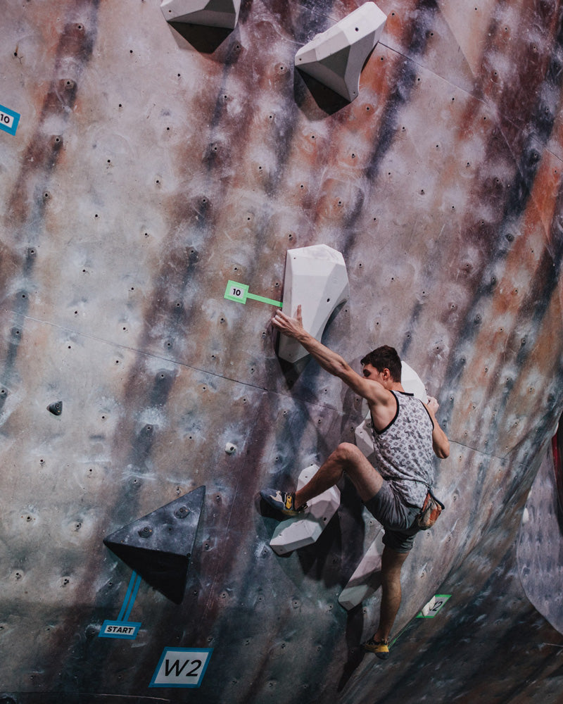 A climber climbs on the so ill level family holds during a climbing competition