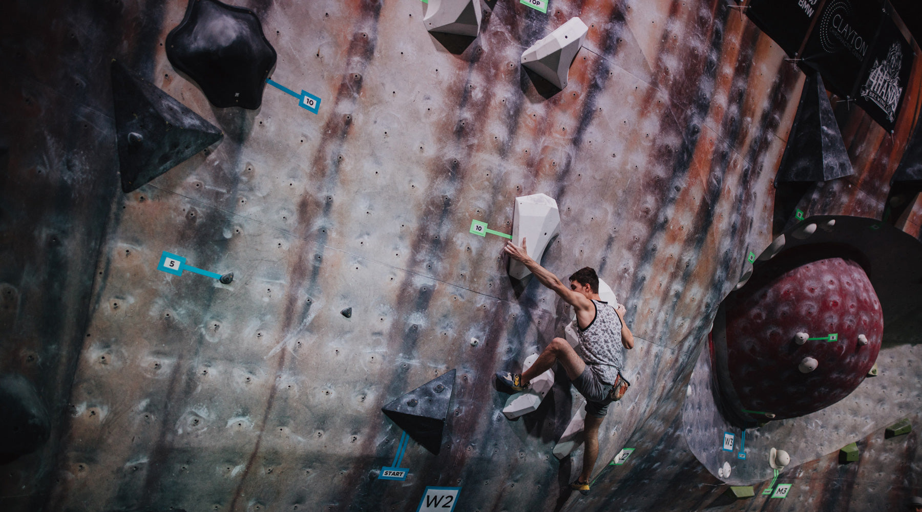 A climber climbs on the so ill level family holds during a climbing competition