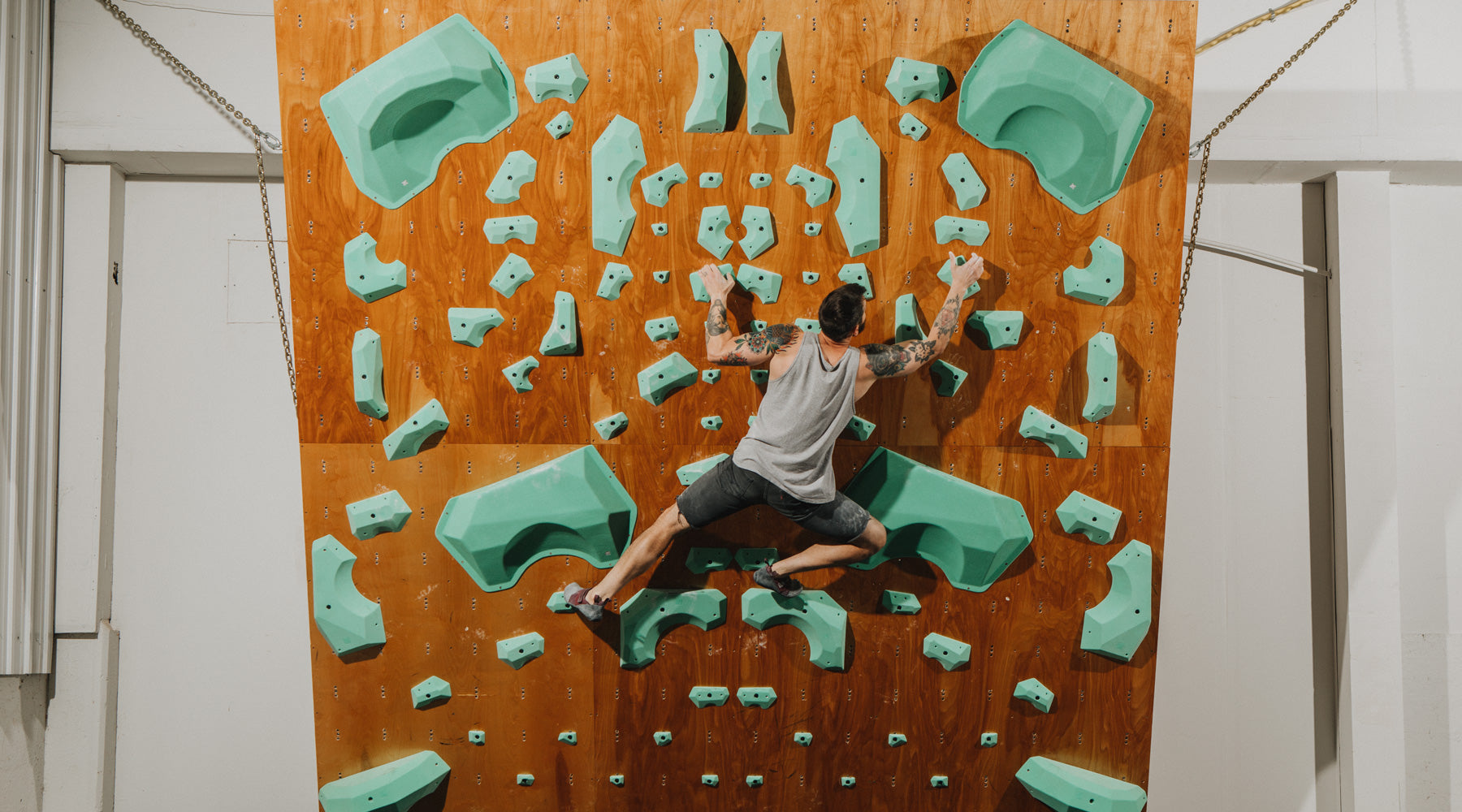 a climber climbs on the so ill level family holds inside of a warehouse