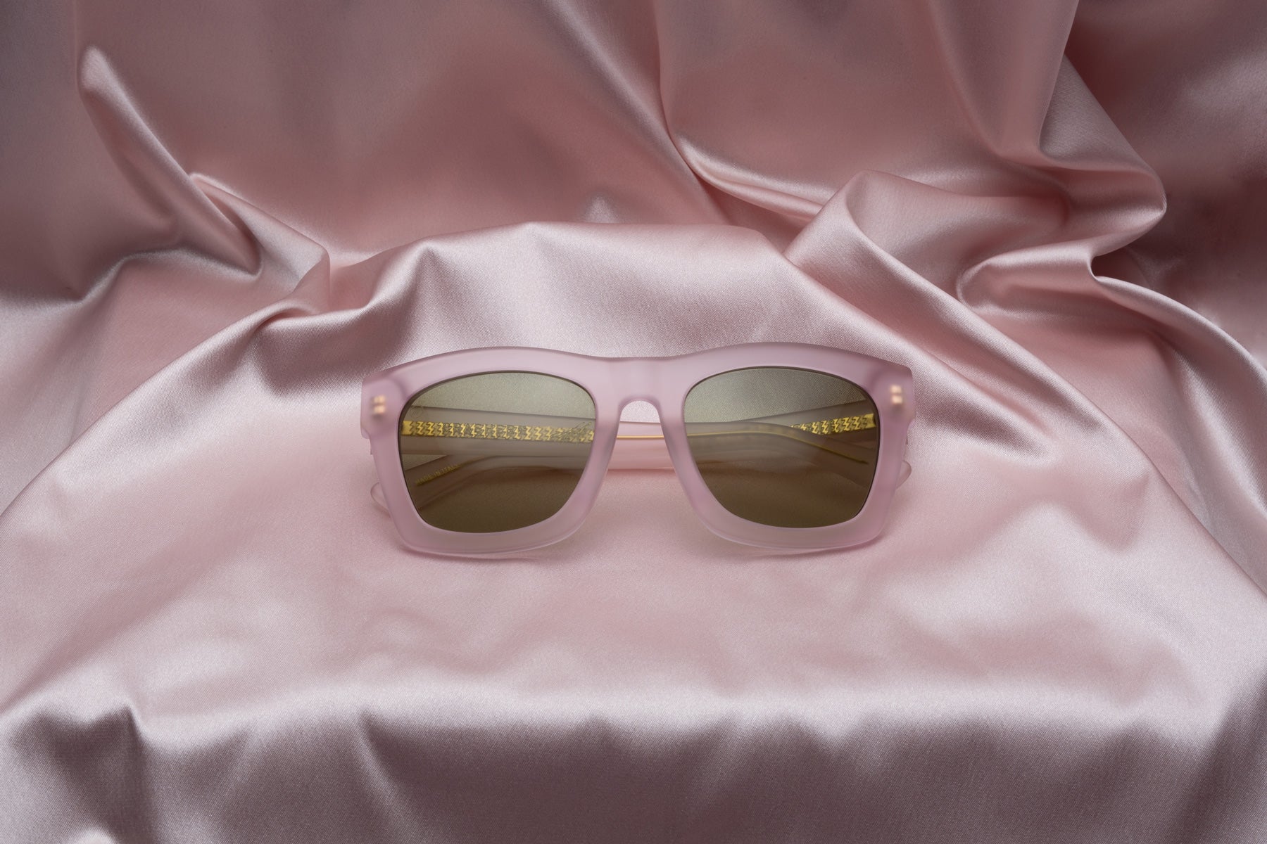 matte pink electric sunglasses shown on a pink background