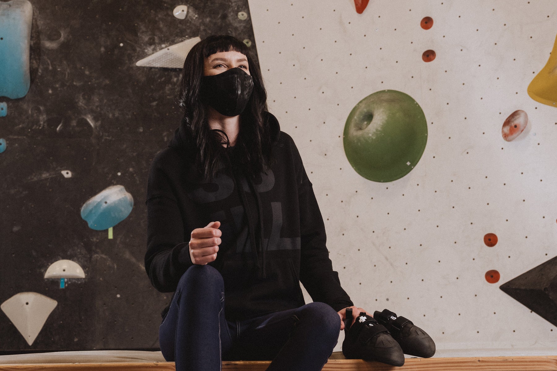 a woman gets ready to climb at climb so ill in the so ill black stacked logo hoodie