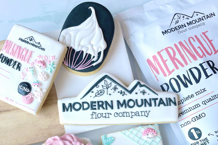 Pouch of Modern Mountain Meringue Powder next to royal icing cookies