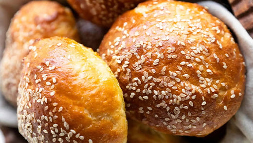 A pile of golden brown potato flour brioche burger buns