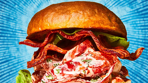 A stacked lobster BLT on a potato flour roll