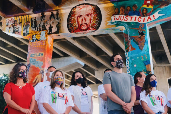 Alliance San Diego members stand in front of Chicano Park, San Diego