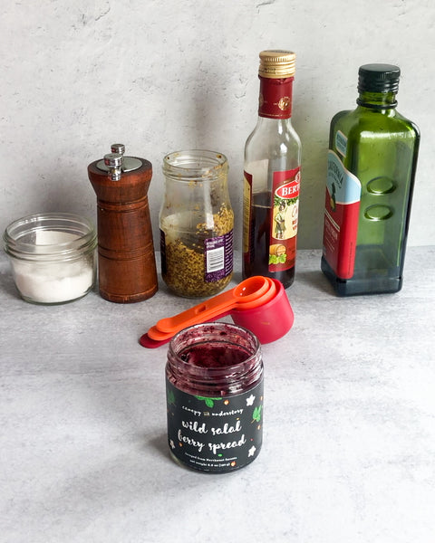 wild salal berry jam jar, nearly empty, with salt, pepper, dijon mustard, red wine vinegar, and olive oil