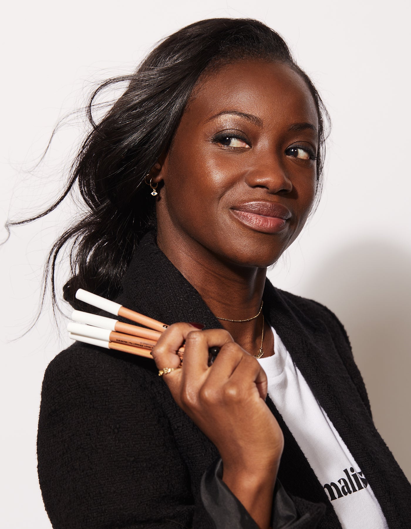 A woman holding The Best Pencils by Jones Road Beauty