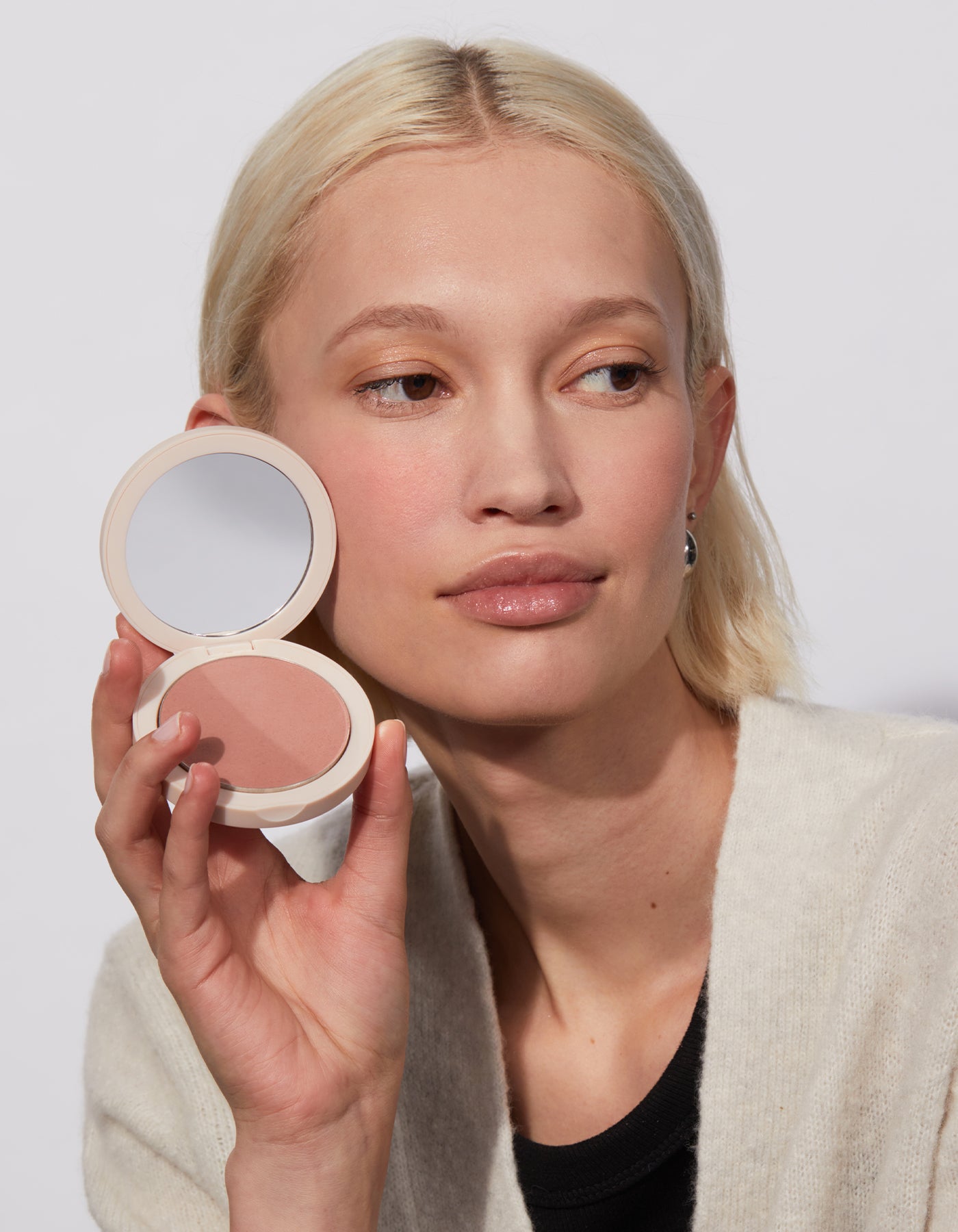 A woman holding The Bronzer in Dusty Rose by Jones Road