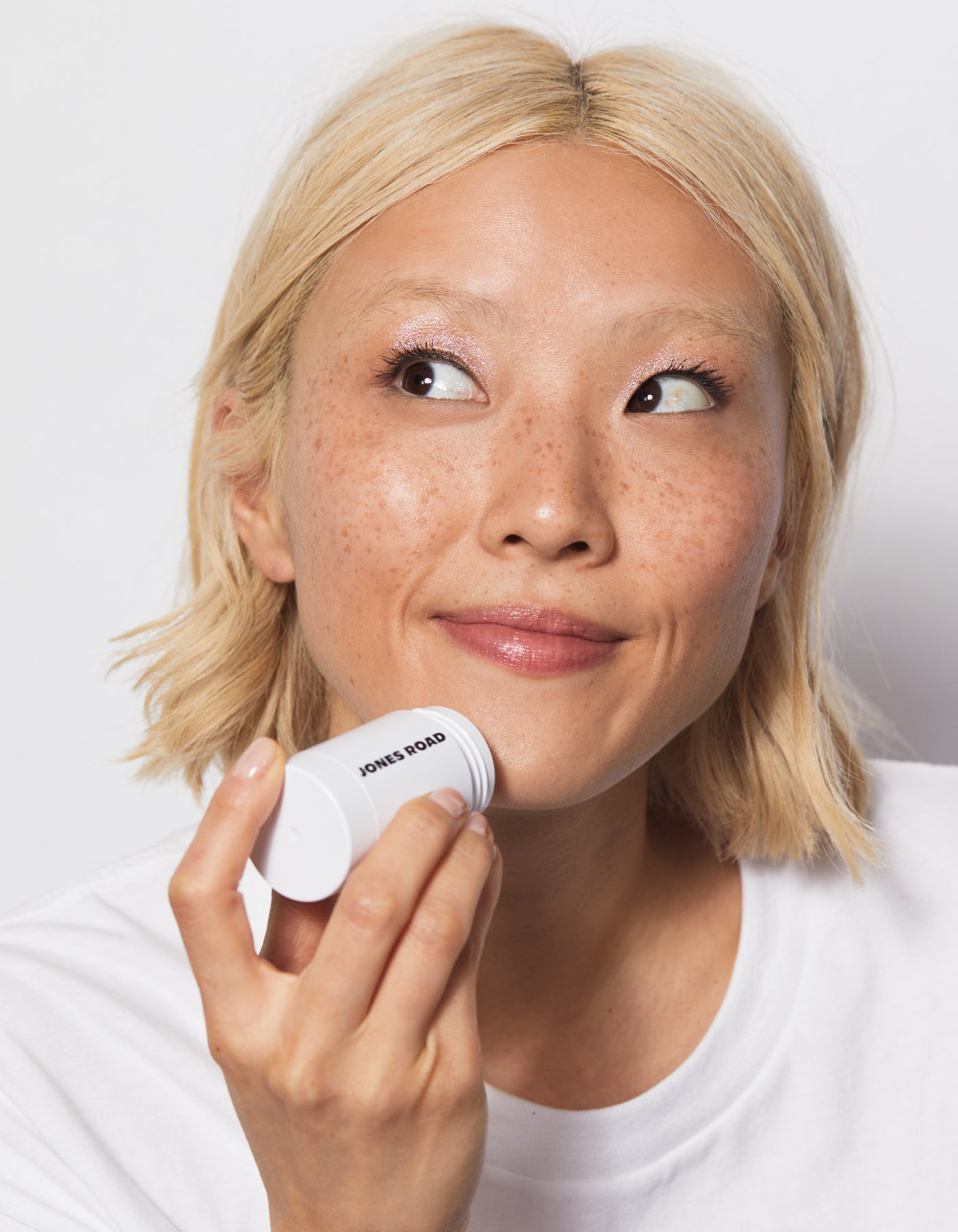 A woman using The Cleansing Stick by Jones Road