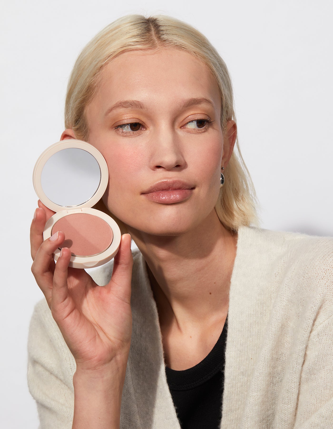 Model holding Jones Road Beauty blush.