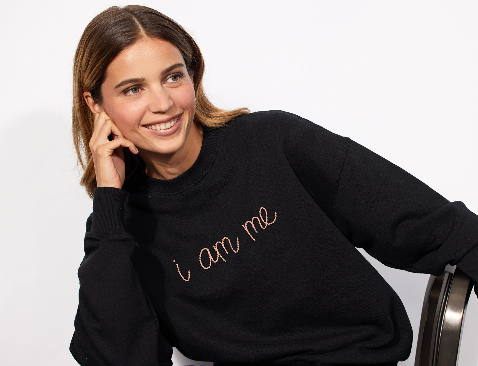 A woman wearing the "i am me" Jones Road x Lingua Franca sweatshirt