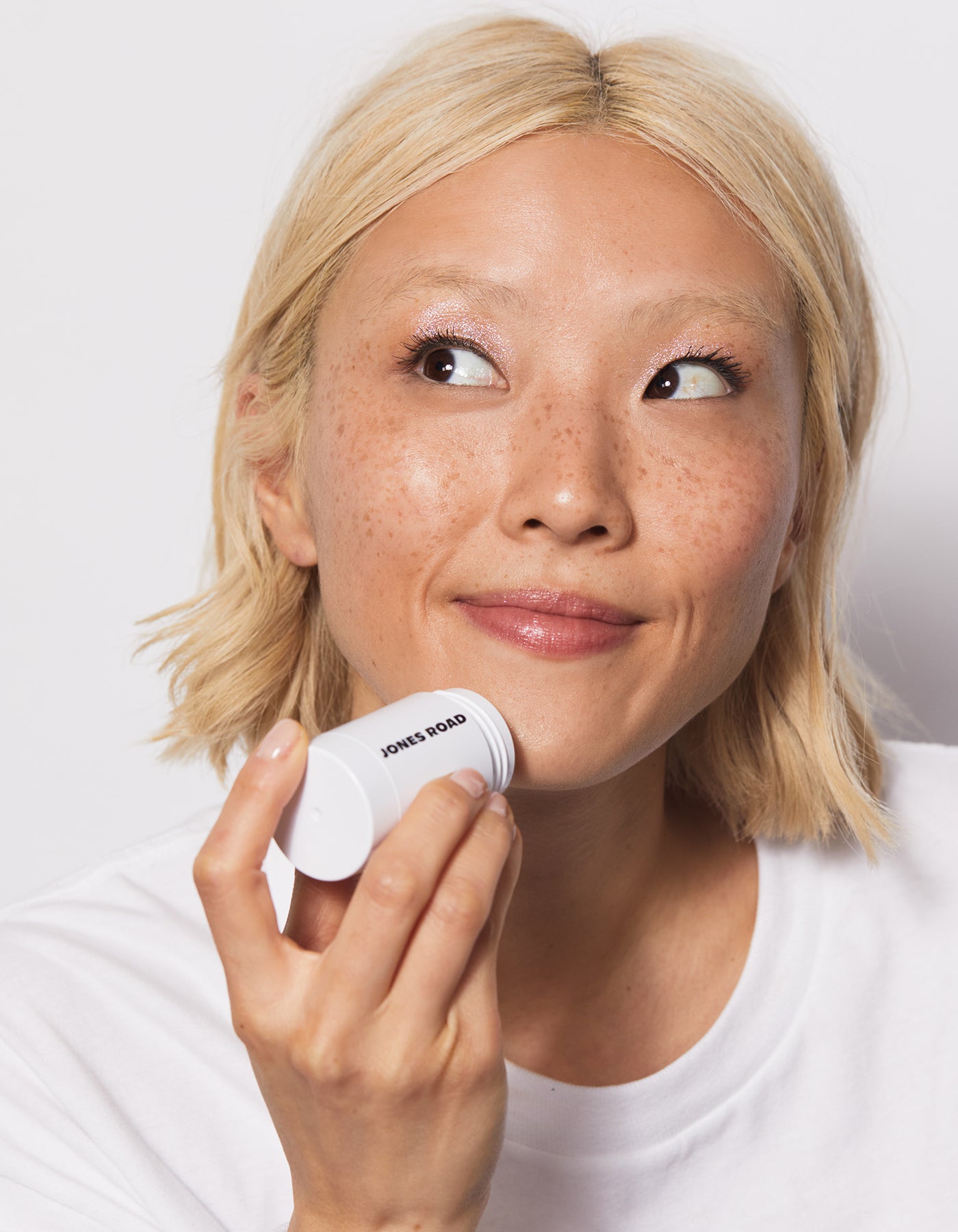 Model using cleansing stick on dry skin