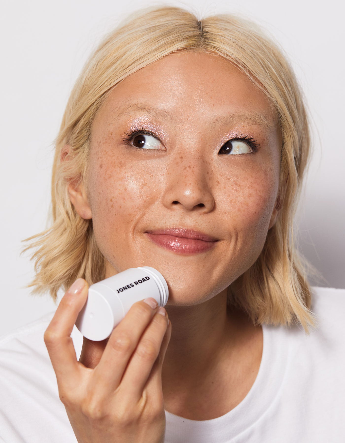 Jones Road Beauty model with the cleansing stick