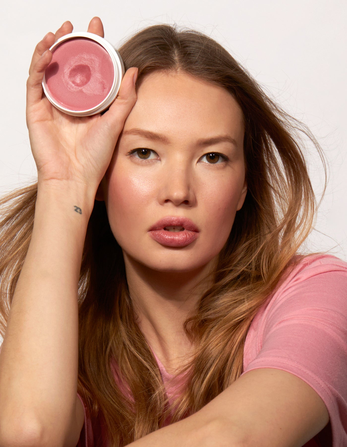 Jones Road Beauty model holding miracle balm