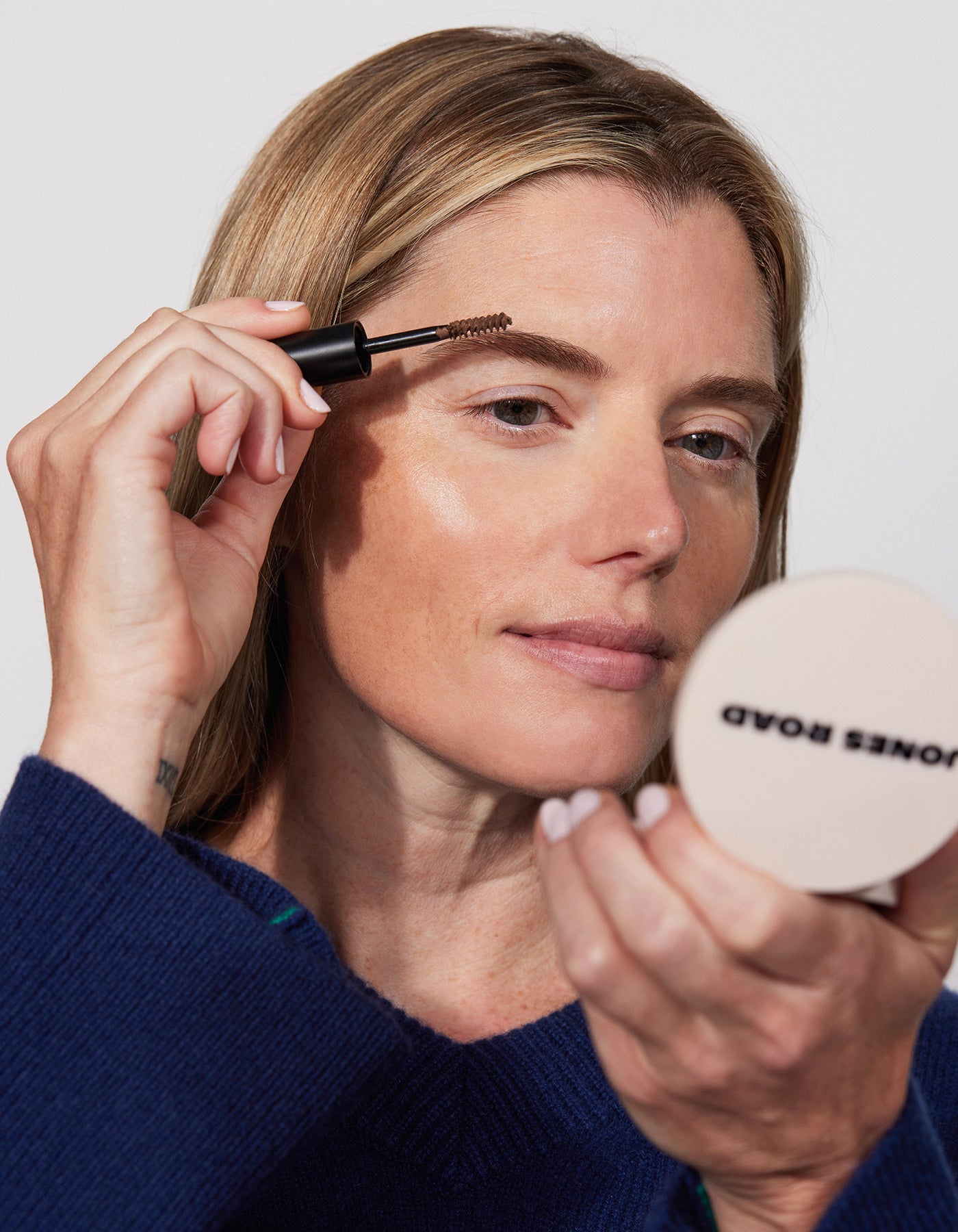 A woman using The Brow Gel by Jones Road