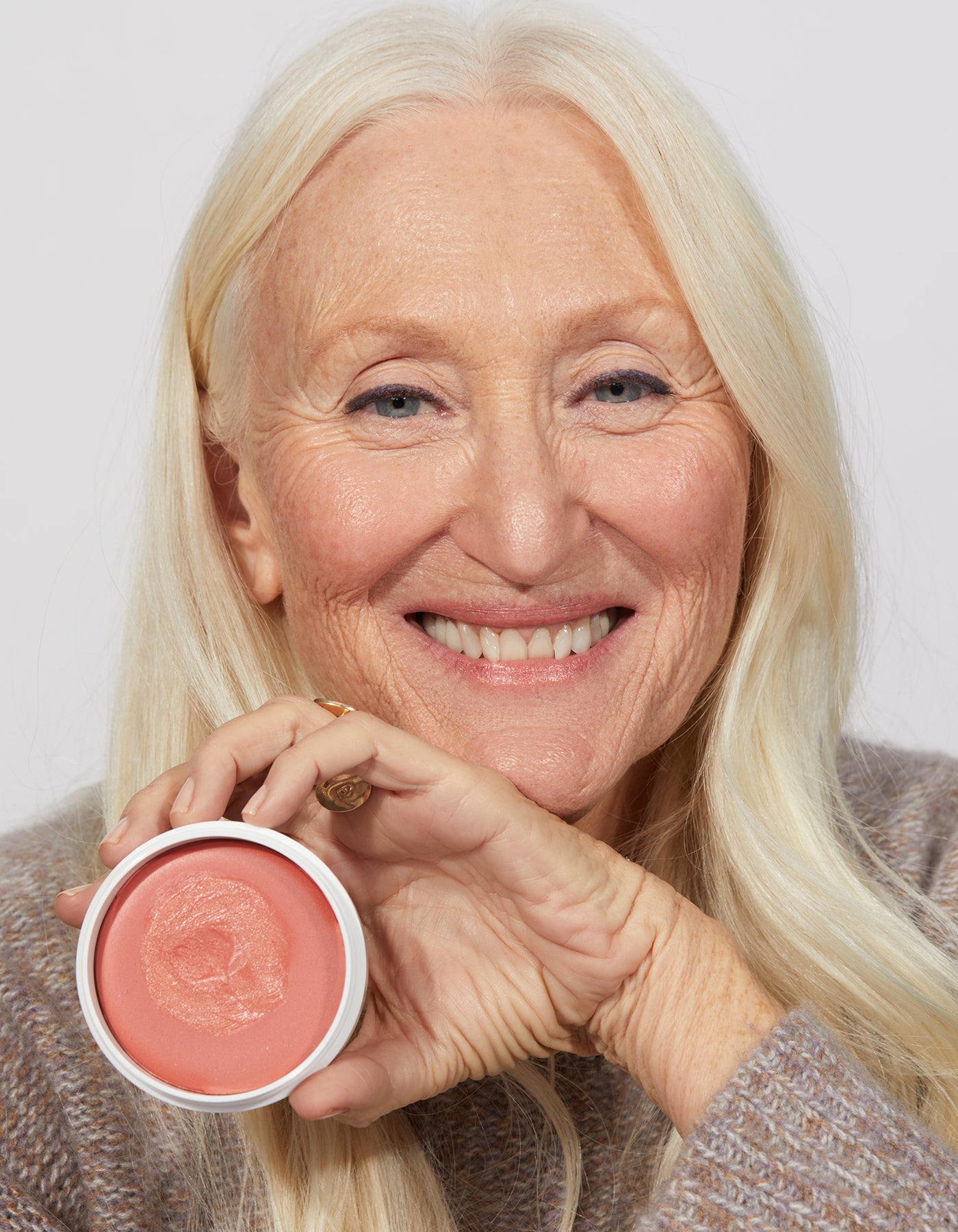 A woman holding Miracle Balm by Jones Road