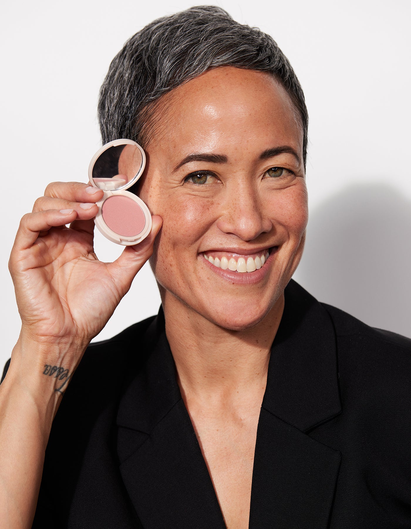 Jones Road Beauty model holding a blush.