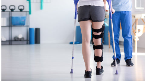 woman recovering with leg brace and crutch