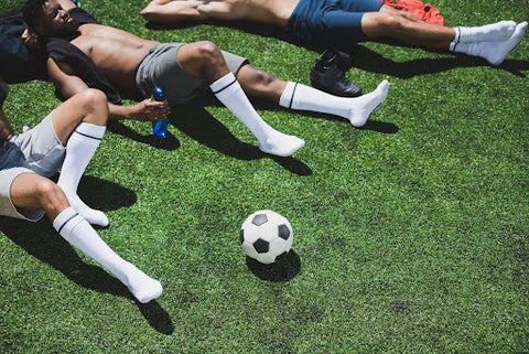 Exhausted soccer players in need of the best soccer slides for recovery.