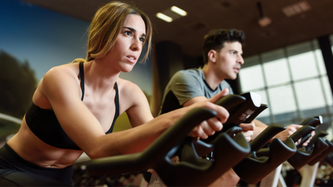 A woman and a man in a spinning class