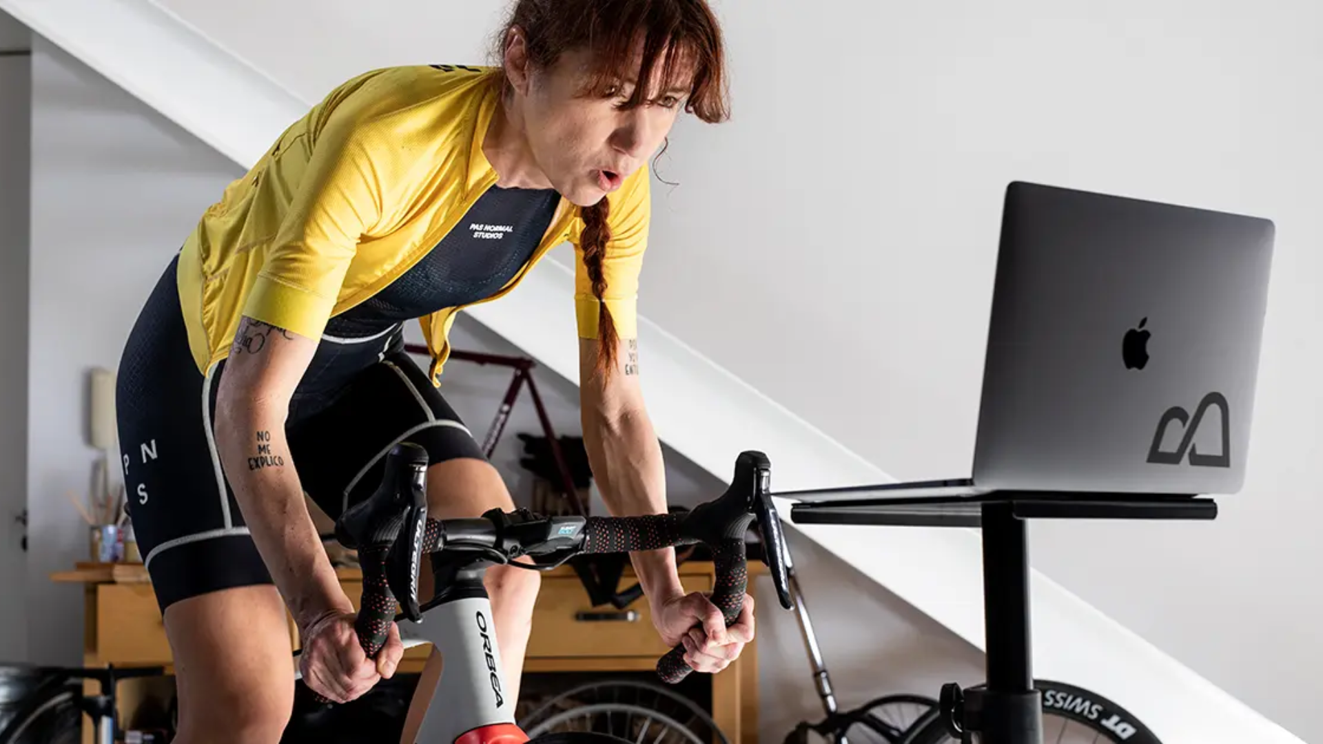 Mulher treinando em casa com o simulador de ciclismo Bkool