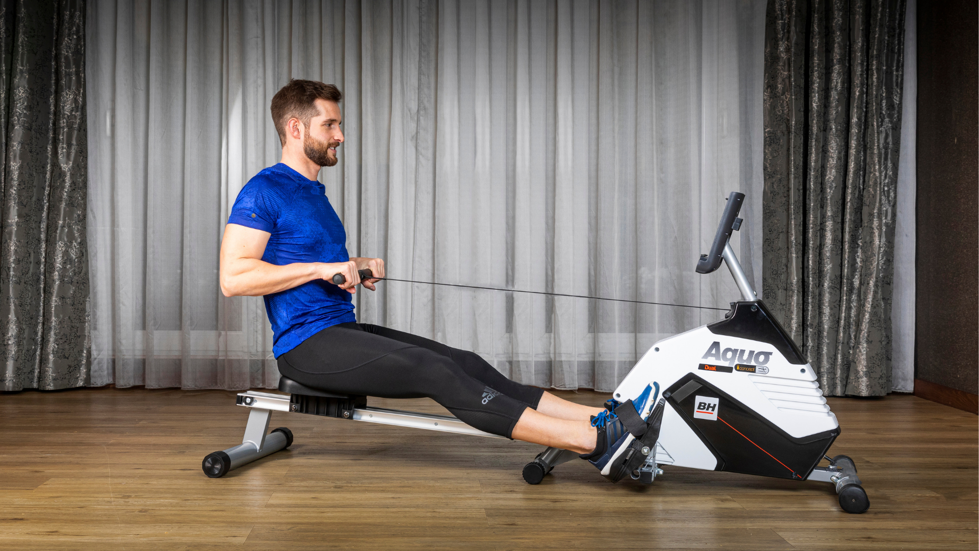 Man exercising on the BH Fitness Aquo Dual rower,