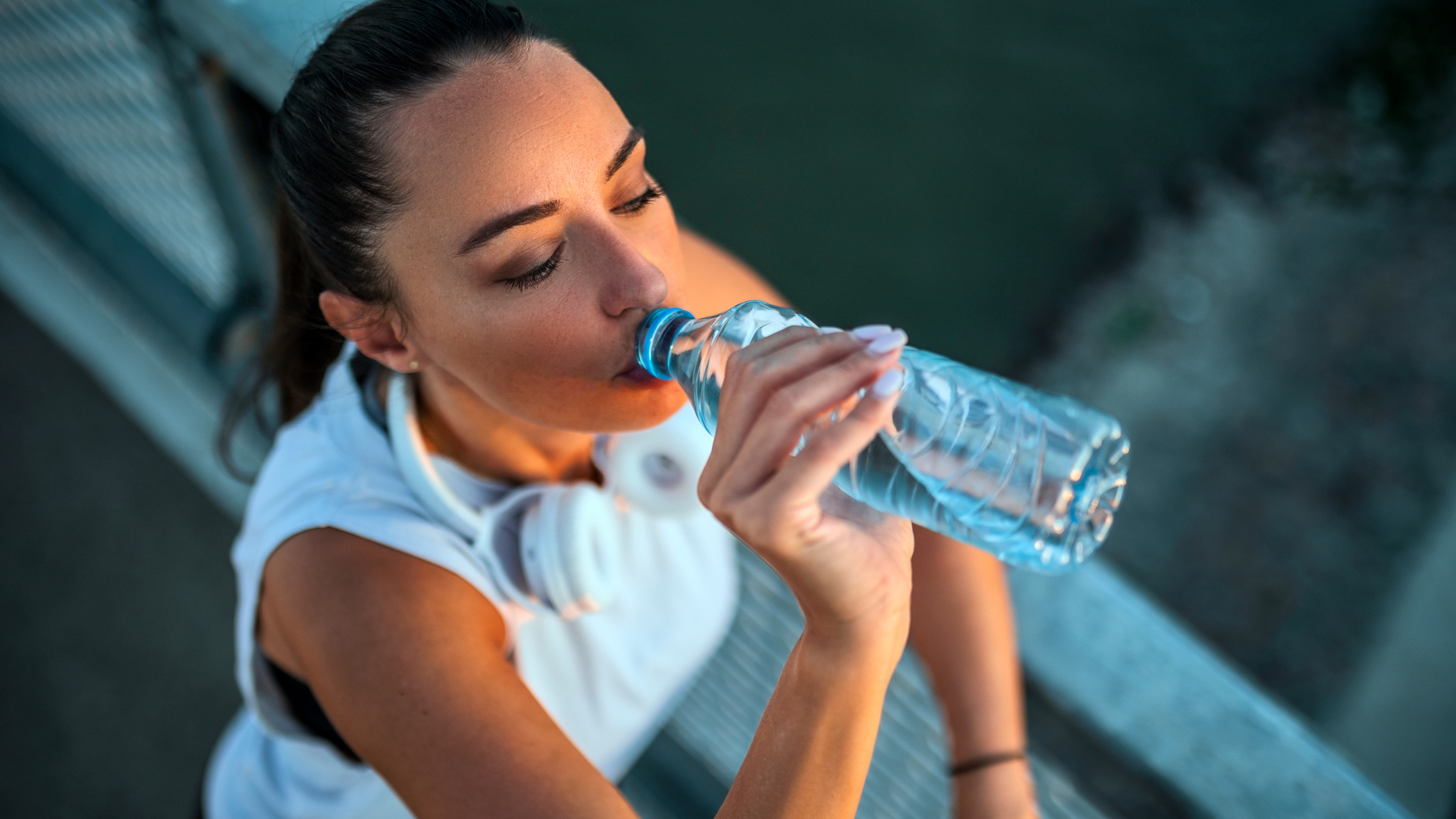 mujer bebiendo agua mientras entrena