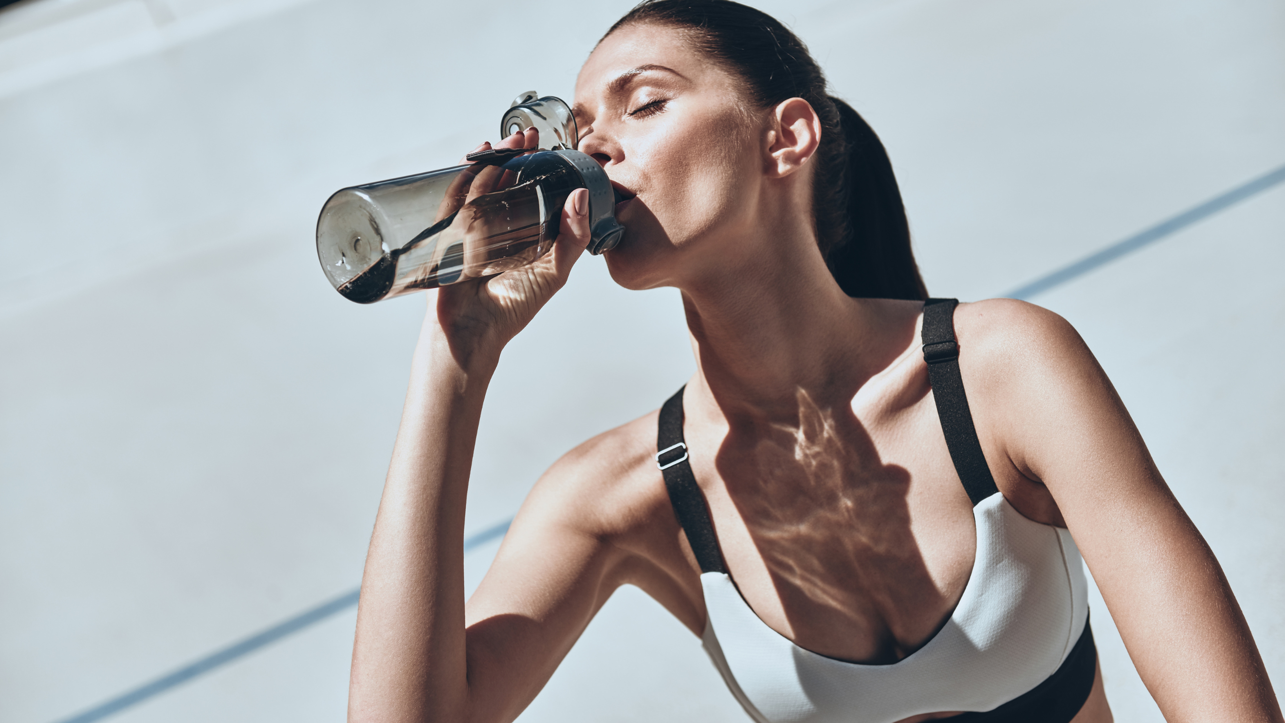 mujer hidratándose tras realizar ejercicio