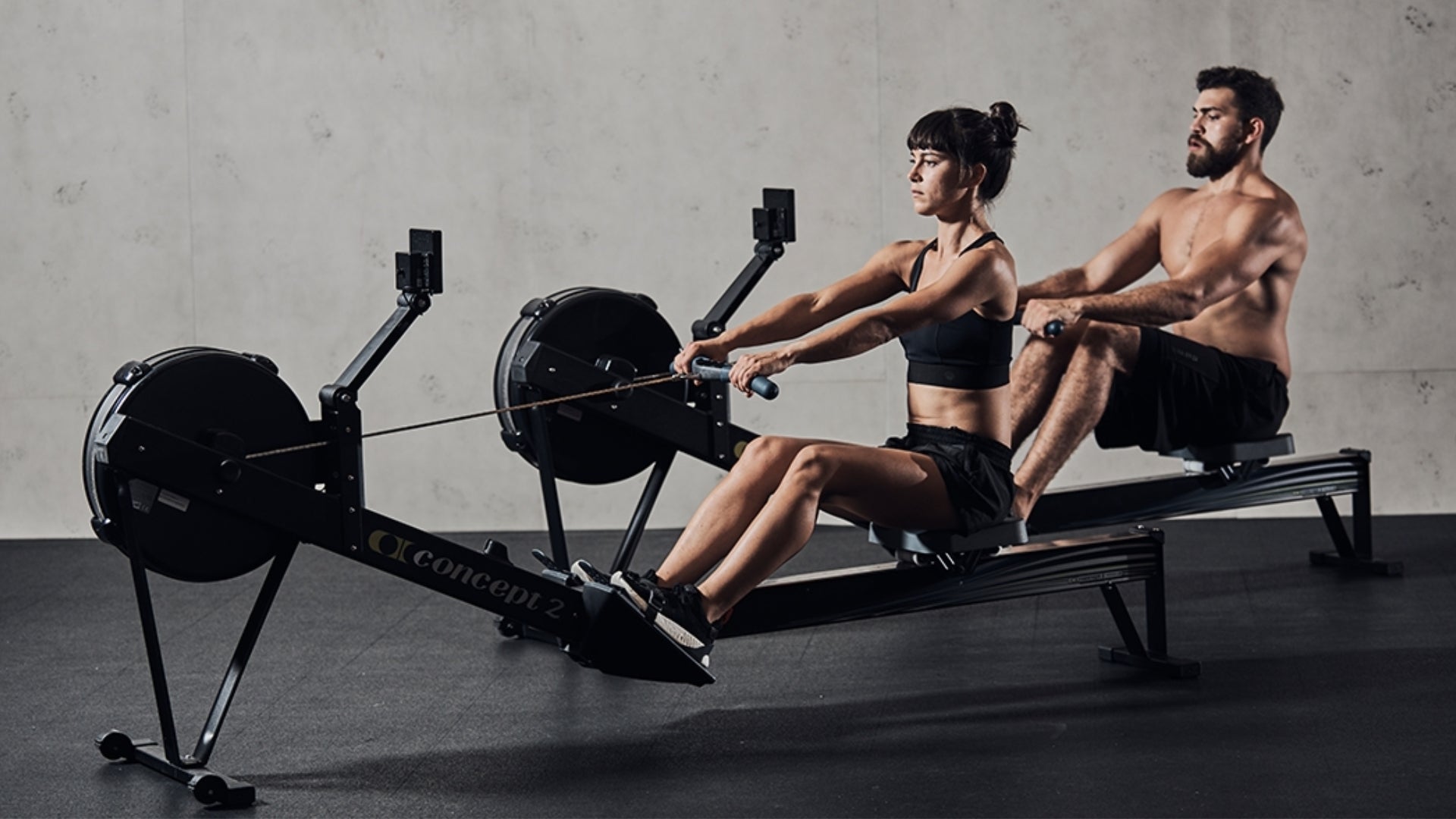 Hombre y mujer encima de los remos Concept2 permitidos en el III Circuito Open de Remo Indoor