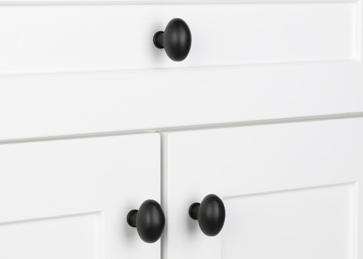 Three Aeg cabinet knobs installed on a white vanity.