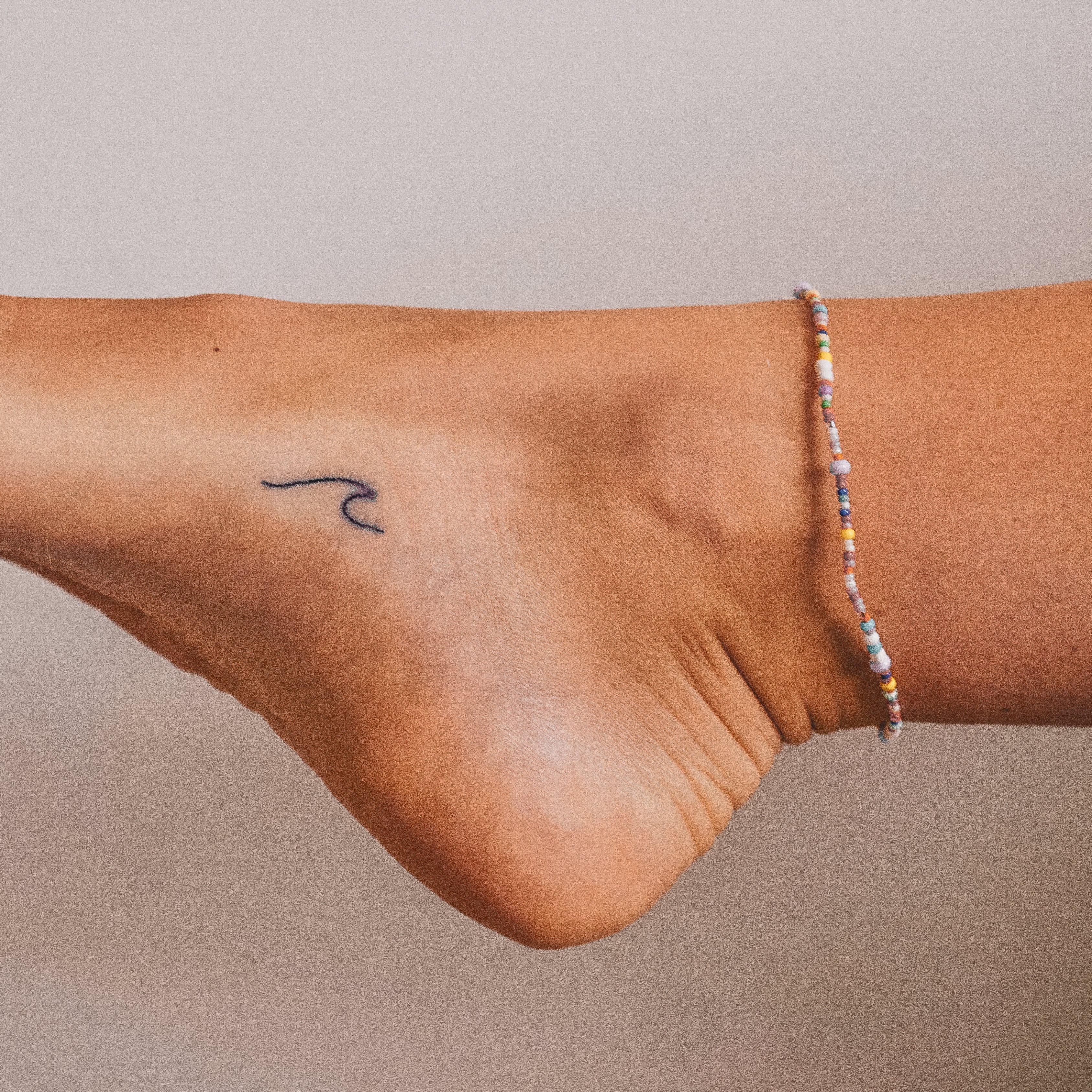 Wave Tattoo On Girl Ankle