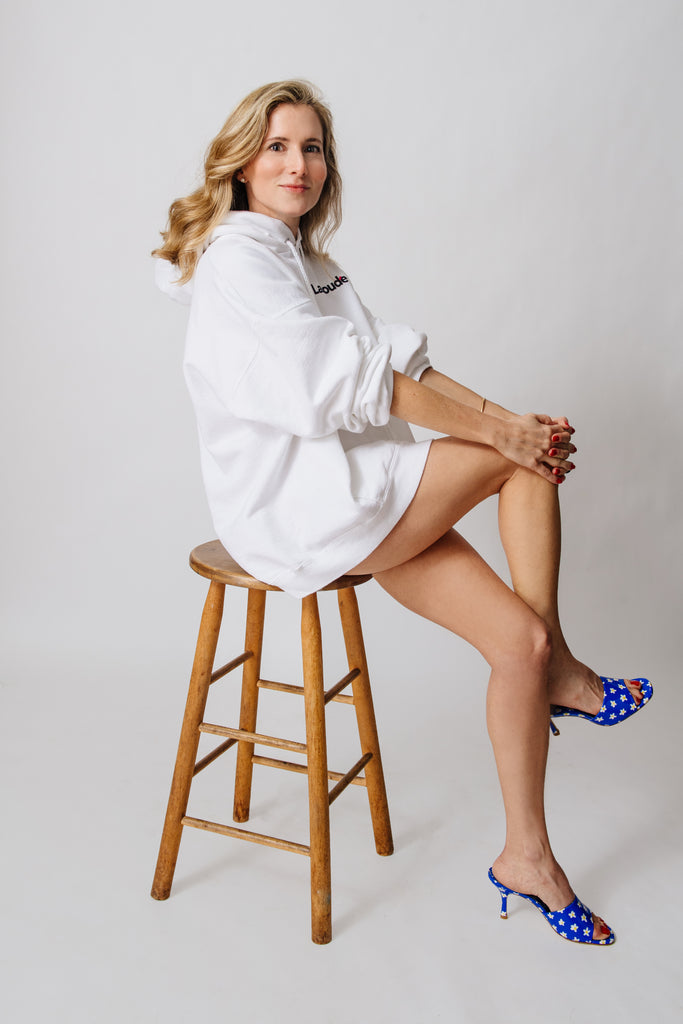 Marina Larroudé dress in white sitting on a stool 