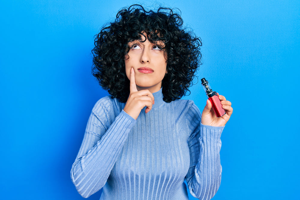 Woman looking puzzled holding a vaping device