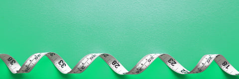 Coiled tape measure on green background