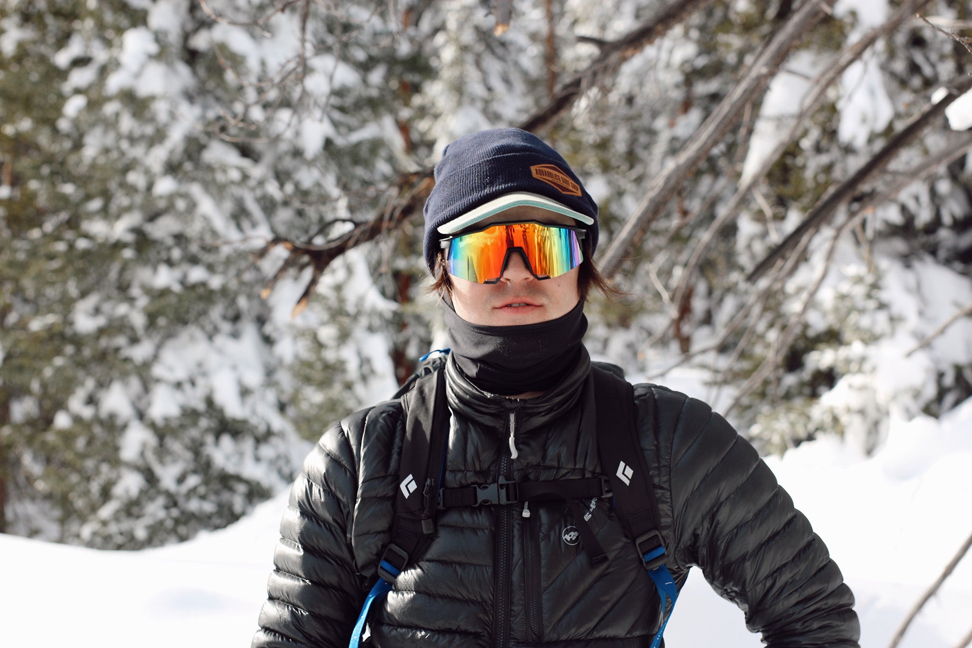 Man in blue jumper climbing above forest line