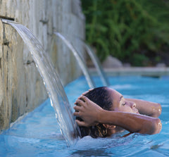 Descente pure en cascade de piscine avec une femme en dessous. Cascades pures Hayward avec LED de couleur.