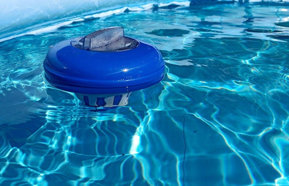 Blue chlorine dispenser floats in a pool