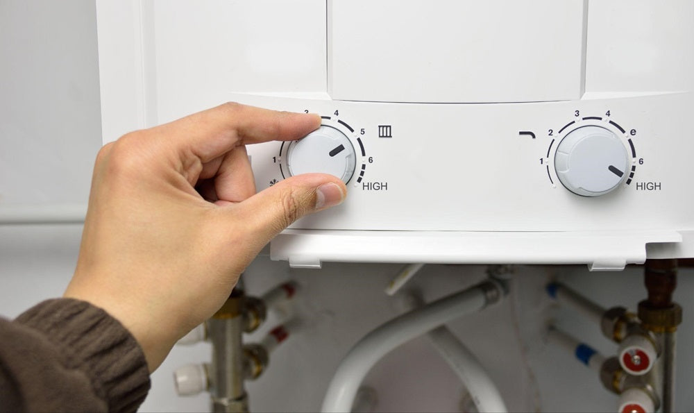 Hand rotating the temperature adjuster of water heater