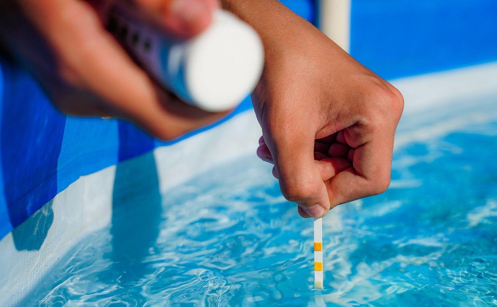 Femme testant des produits chimiques dans l’eau de la piscine