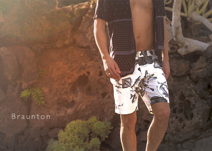 Model wears our Riz Braunton mid length tailored swim shorts for a walk on the beach
