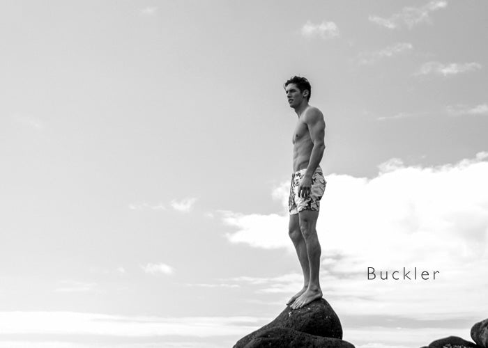 Model wearing the Riz Buckler short length tailored swim short for ocean swimming