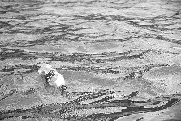 discarded coca cola bottle floating in the sea