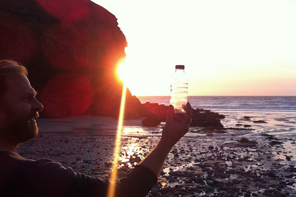 Ali Murrell collecting single use plastic bottles on a sunset beach clean in Cornwall