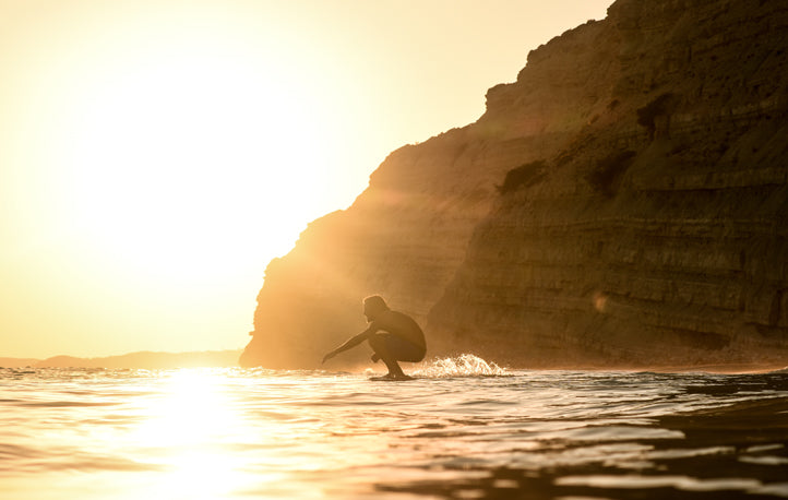 Image of a surfer catching the final waves before the sun sets
