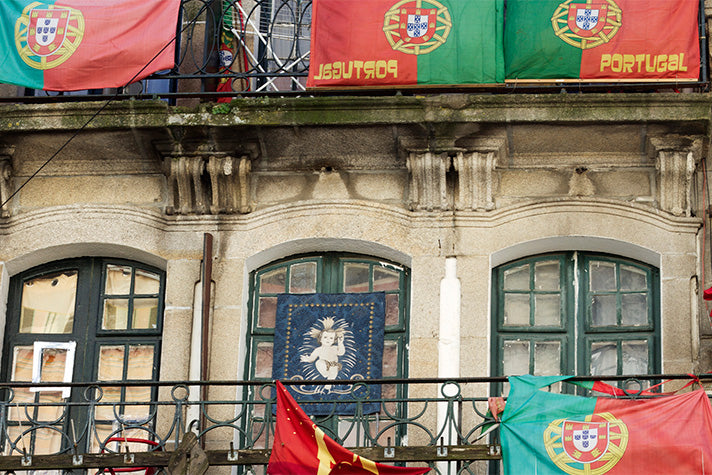 Portuguese flags hanging from windows and balconies in the city of Porto