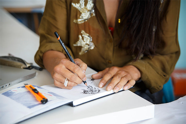 british artist and illustrator kristine khan drawing in her sketchbook