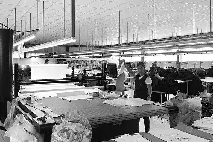 Pattern cutter at the cutting table in the factory in Portugal where Riz boardshorts' men's swim shorts are made