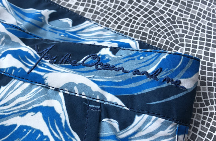 The You The Ocean and Me logo embroidered in the waistband of our blue collection swim shorts