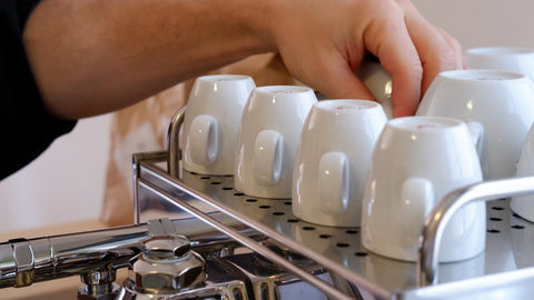 Espresso Tassen auf Siebtraeger mit Hand
